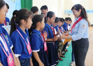 Chị Lê Thị Thanh Bích - Phó Bí thư Tỉnh Đoàn, Chủ tịch Hội đồng Đội tỉnh trao giấy chứng nhận cho các em đội viên, thiếu nhi.