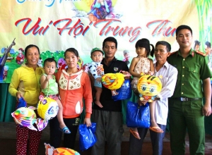 Trung úy Ngô Nguyễn Quốc Cường (bên phải) tặng quà cho các em thiếu nhi có hoàn cảnh khó khăn đang điều trị tại bệnh viện Sản - Nhi tỉnh.