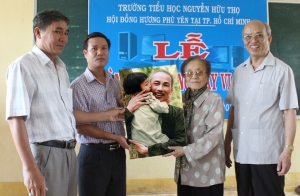 GS-TS Trình Quang Phú (bìa phải) cùng nguyên Phó Chủ tịch nước Nguyễn Thị Bình tặng ảnh Chủ tịch Hồ Chí Minh cho Trường tiểu học Nguyễn Hữu Thọ.