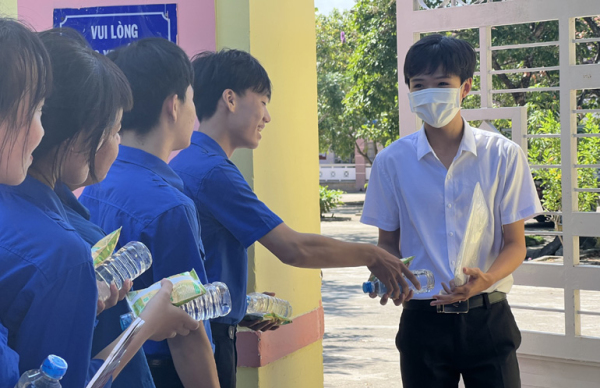 Tình nguyện viên tiếp sức mùa thi tại điểm Trường THPT Nguyễn Du (huyện Sông Hinh) hỗ trợ nước uống và sữa cho thí sinh.