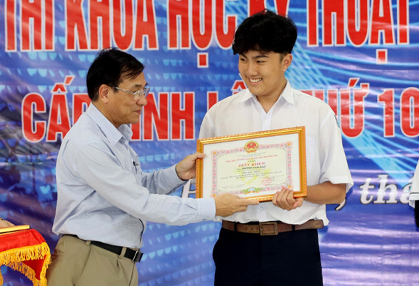 Giám đốc Sở GD-ĐT Trần Khắc Lễ trao giải nhất cho em Huỳnh Thái Bảo.