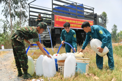 Lực lượng vũ trang tỉnh Kiên Giang bơm nước vào can nhựa cho người dân xã Phú Mỹ, huyện Giang Thành - Ảnh: PHƯƠNG VŨ