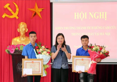 Lãnh đạo UBND tỉnh Nam Định trao bằng khen cho 2 thanh niên dũng cảm cứu người trong vụ cháy rạng sáng 24-5 tại Hà Nội - Ảnh: TTXVN