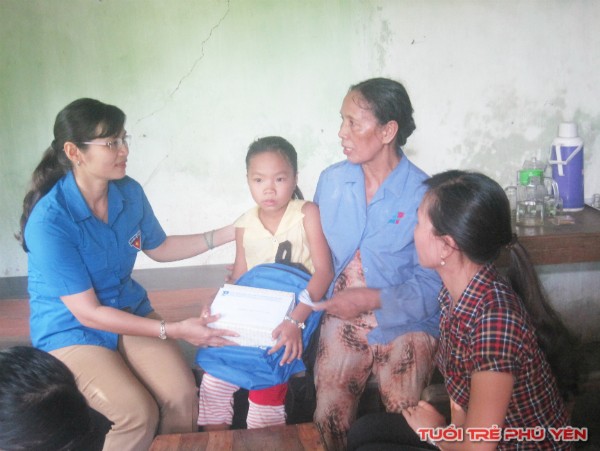 Phó Bí thư Tỉnh Đoàn, Chủ tịch Hội đồng Đội tỉnh Lê Thị Thanh Bích trao quà và tiền cho 01 em học sinh khó khăn ở huyện Đông Hòa.