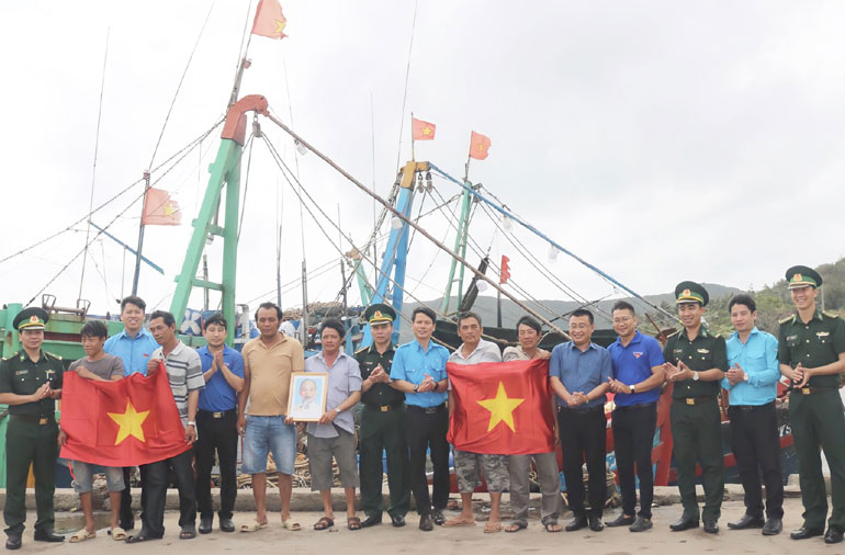 Đoàn viên thanh niên, cán bộ, chiến sĩ trao tặng cờ Tổ quốc và ảnh chân dung Bác Hồ cho ngư dân phường Xuân Đài.
