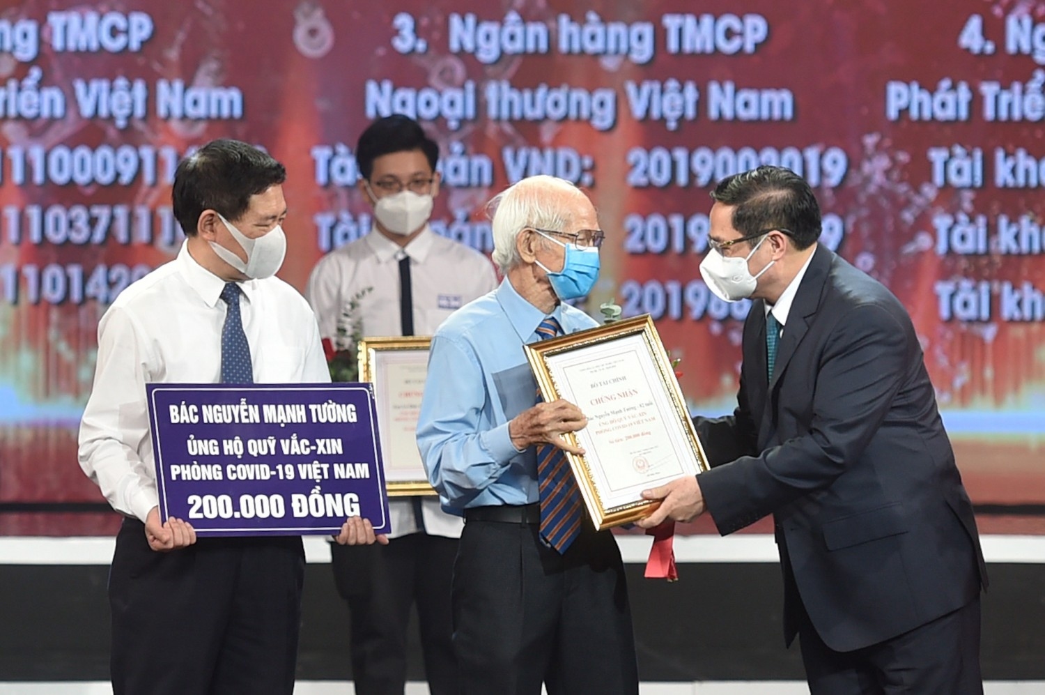 Thủ tướng Chính phủ Phạm Minh Chính trao chứng nhận, hoa cảm ơn bác Nguyễn Mạnh Tường 82 tuổi, cán bộ hưu trí ngành đường sắt ủng hộ Quỹ Vaccine.