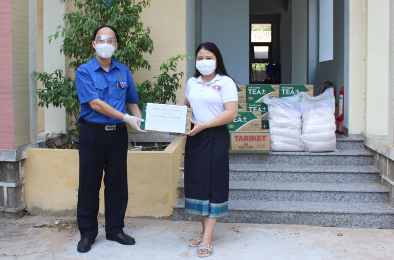 Anh Trần Minh Trí tặng quà cho đại diện sinh viên Lào đang học tập tại Trường đại học Xây dựng Miền Trung.