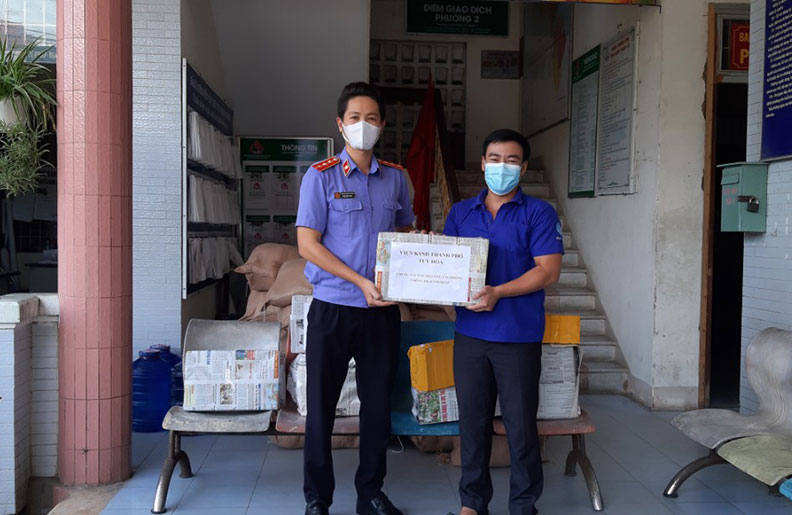 Anh Phạm Đình Huy (bìa phải) tiếp nhận nguồn lực ủng hộ phòng chống dịch cho địa phương từ Viện KSND TP Tuy Hòa.