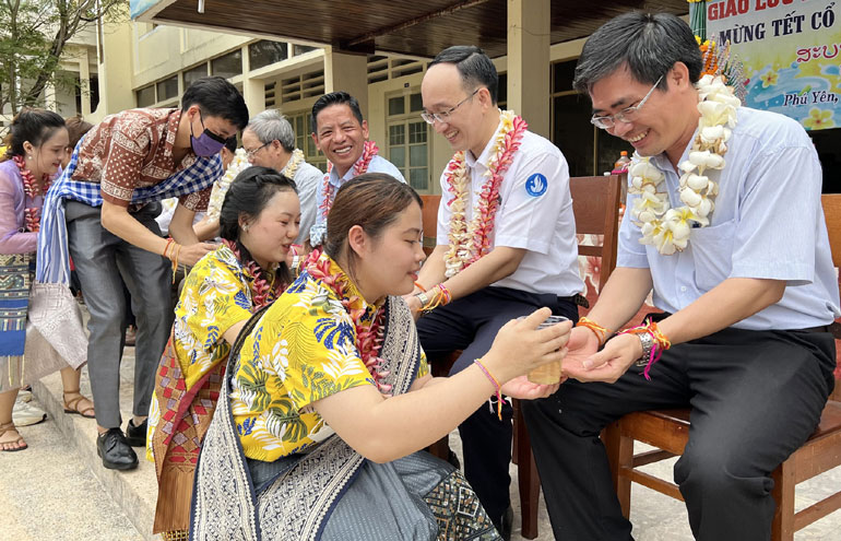 Lưu học sinh Lào đang học tại Trường đại học Xây dựng Miền Trung thực hiện nghi lễ vẩy nước thơm, chúc phúc cho lãnh đạo nhà trường và đại biểu nhân Tết cổ truyền Bunpimay.