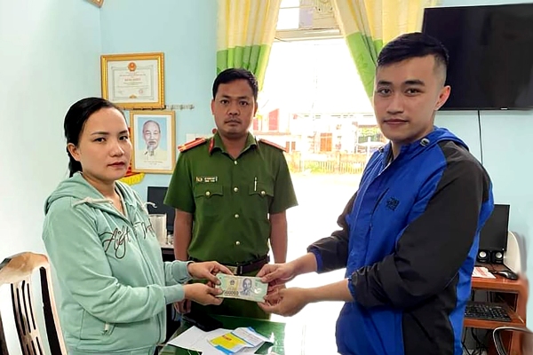 Chị Lê Thị Yến Thu trao lại chiếc ví gồm giấy tờ và gần 39,5 triệu đồng cho anh Tú trước sự chứng kiến của Công an xã Hành Minh.
