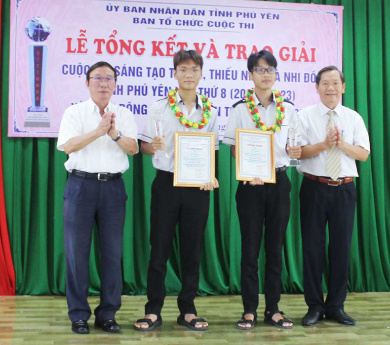 Ban tổ chức trao cúp cho nhóm tác giả đạt giải nhất Vũ Tùng Minh, Ngô Đại Thanh Quang. Ảnh: VĂN TÀI