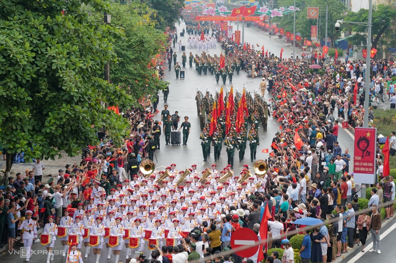 Dù thời tiết có mưa, hàng nghìn người dân vẫn có mặt từ rất sớm, vẫy cờ hoa trên các tuyến phố để chào đón các đoàn diễu binh, diễu hành trong Lễ kỷ niệm 70 năm Chiến thắng Điện Biên Phủ. (Ảnh: VnExpress)  