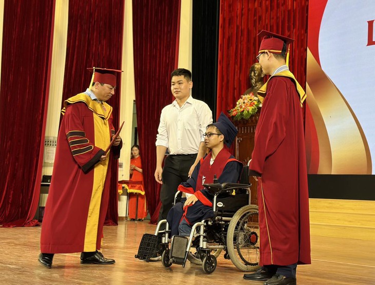 Ngô Văn Hiếu (áo trắng) hỗ trợ Minh lên bục nhận bằng tốt nghiệp đại học - Ảnh: N.B